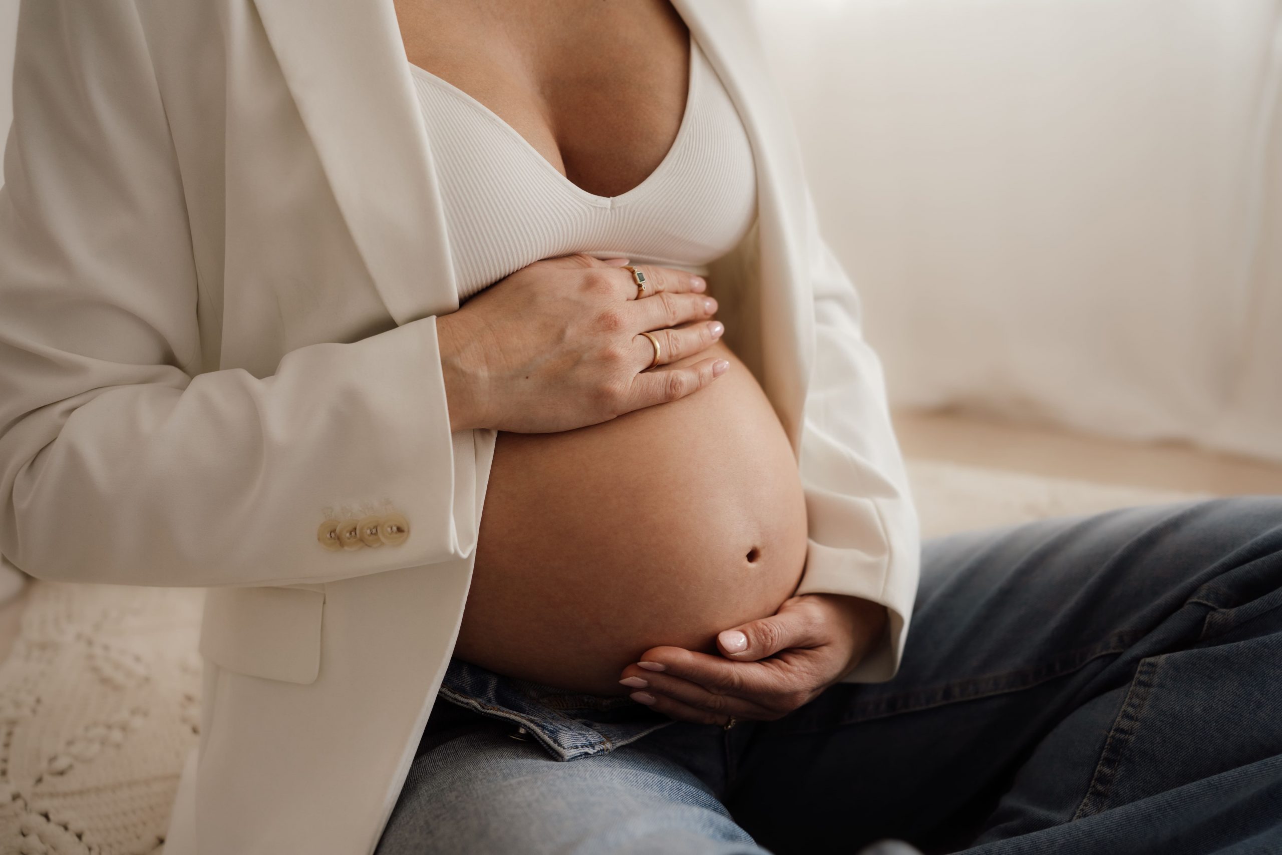 Schwangere Frau hält ihren Babybauch fest